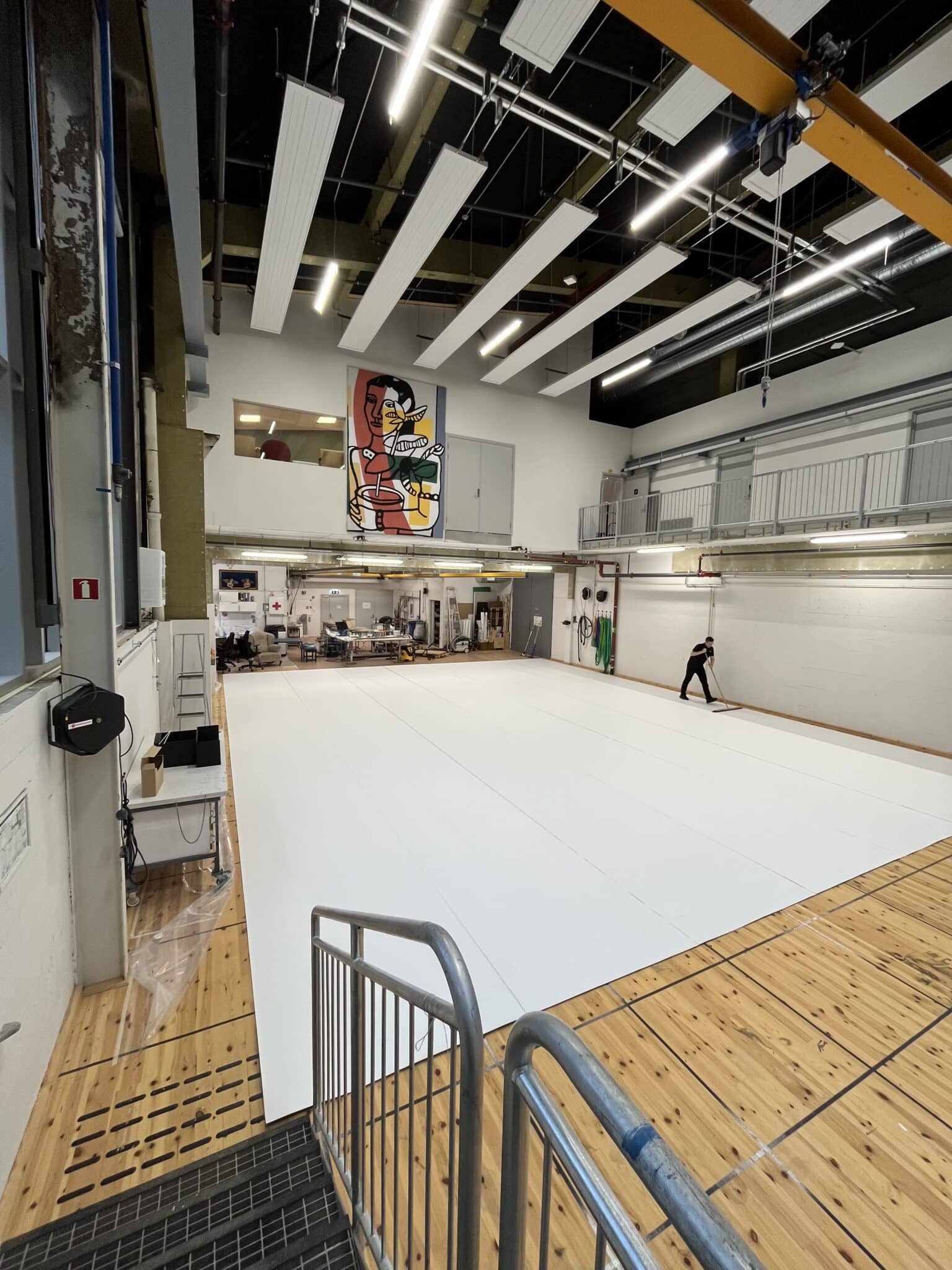 Wide view of the painting workshop with a freshly laid white floor surface. Oversiktsbilde av malersalen med et nylagt hvitt gulv.